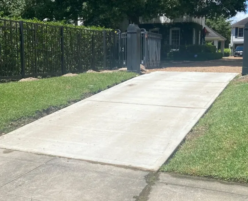 Side-angle view showing the finished concrete driveway entrance